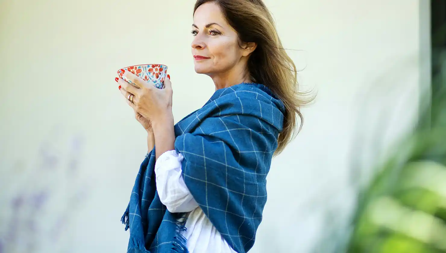 Mature woman relaxed and contemplating with mug of tea