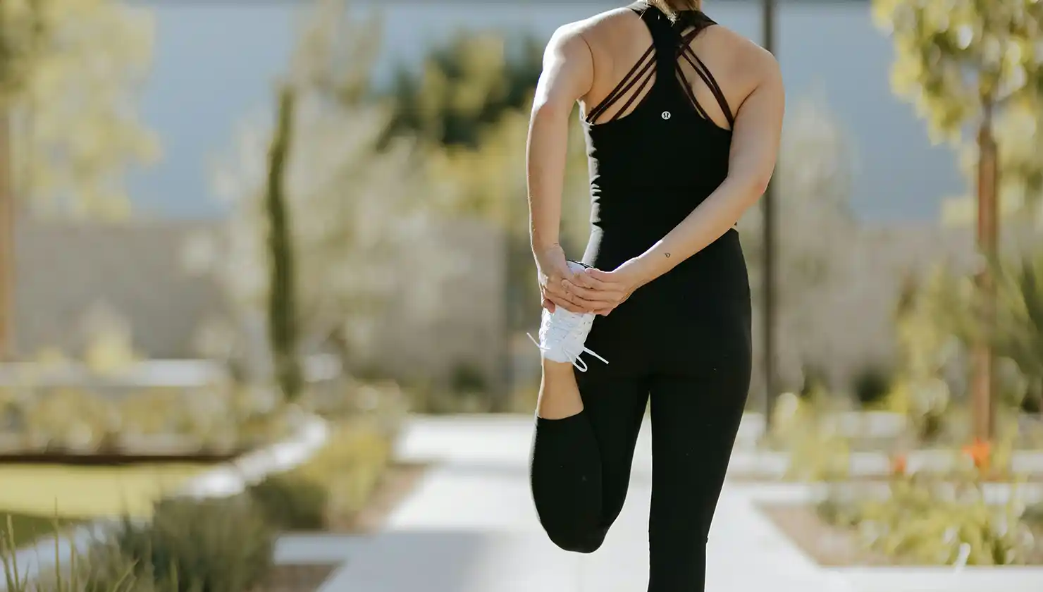 Potential tummy tuck candidate - woman in good shape stretching outdoors who might be having a hard time tightening her abdominal muscles.