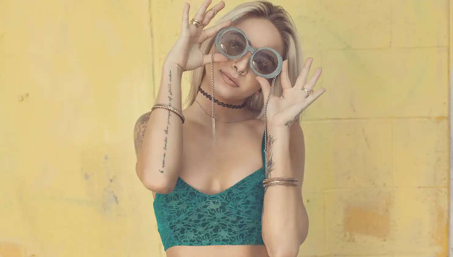 Potential breast augmentation patient posing for a photo with round sunglasses