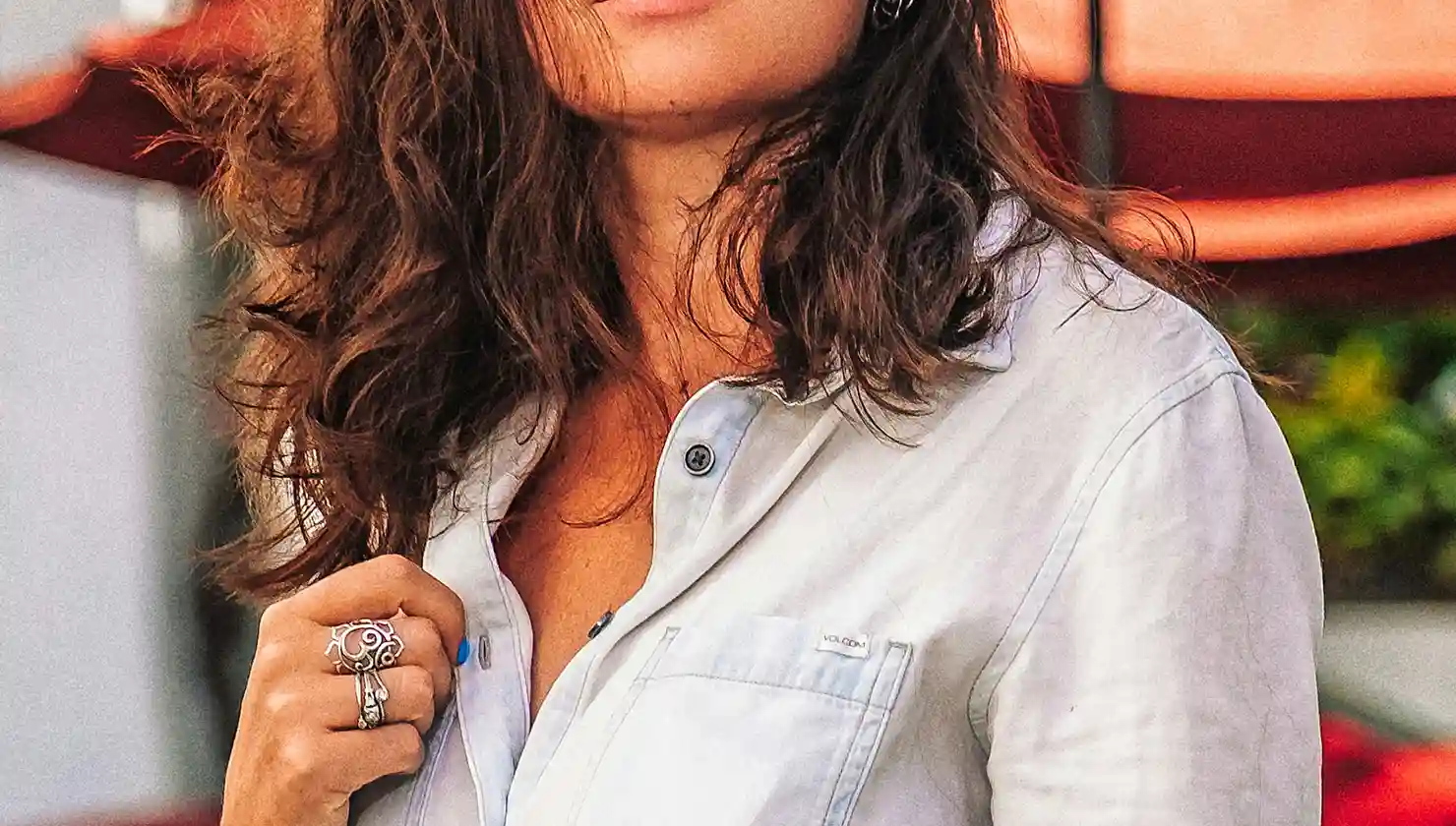 Potential breast cancer reconstruction patient. Woman with a button up shirt and purse strap over shoulder.