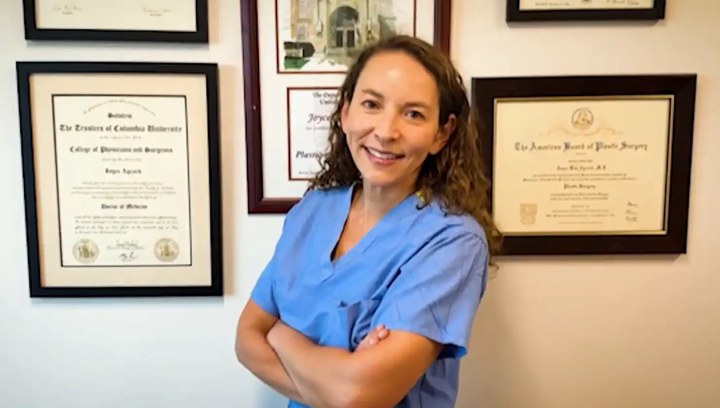 Dr. Joyce Aycock, safe plastic surgeon, in front of certificates - ABPS board-certified plastic surgeon